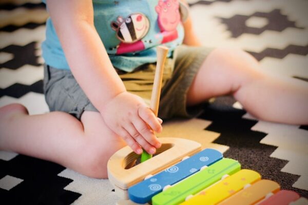 おもちゃの楽器のバチを持つ子供