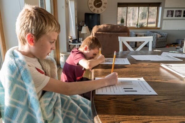 男の子二人がリビングのテーブルでプリントを解いている